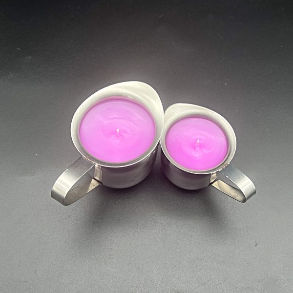 5 ounce (left) and 3 ounce (right) stainless steel container with pour spout and handle and 3 ounce container filled with pink paraffin wax for wax play