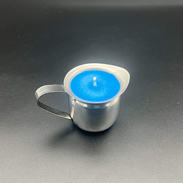 Small stainless steel 3 ounce container with handle and pour spout filled with blue soy candle wax.