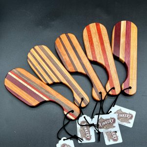 Five pocket paddles - small (7 inch length) wooden paddles made from a variety of woods that create vertical stripes in the paddle.