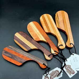 Five pocket paddles on a dark background made in a variety of woods