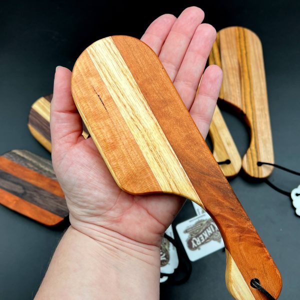 Kayla holding the Pocket Paddle with the paddle area in her palm to give a size comparison. The paddle area is about the size of her hand.