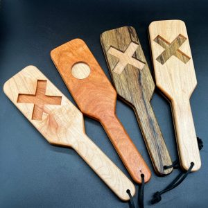 Four XOXO paddles in a row. Wood combos from left to right: Maple and Cherry, Cherry and Maple, Black Limba and Maple, Maple and Black Limba