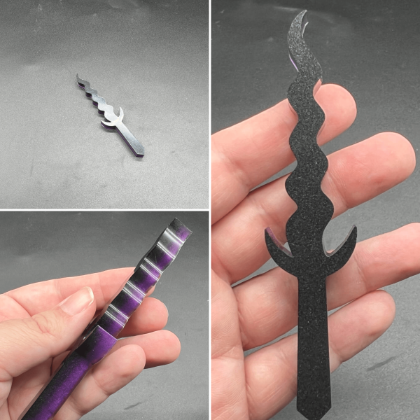 A Kris style dagger made with black resin and purple resin. The black is visible on the front side, and the purple is visible on the back side.