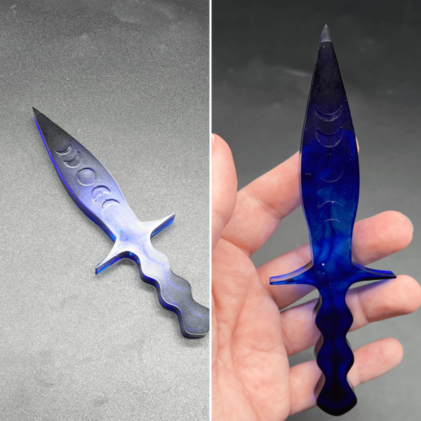 A clear resin with swirls of blue alcohol ink throughout the dagger