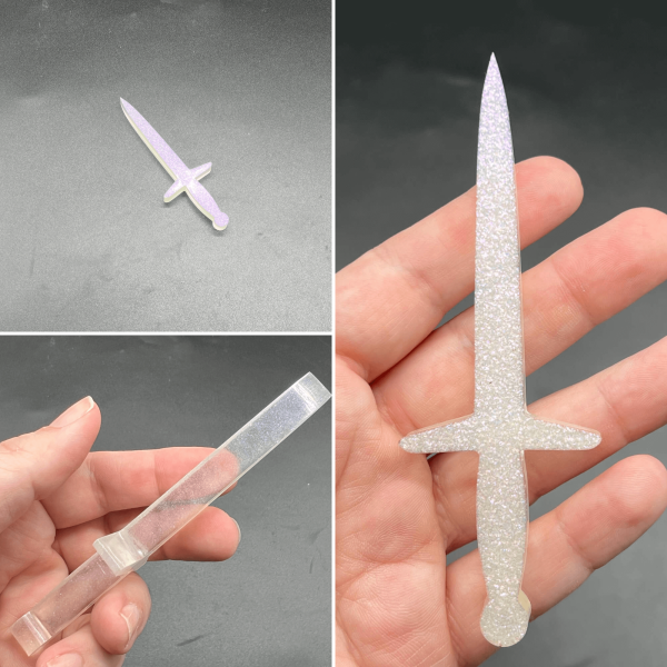 This longsword style dagger is made with clear resin and a color shifting pigment that shifts between white and purple. The pigment sank in the resin so the front side is a sparkly color shift and the rest of the dagger is clear.