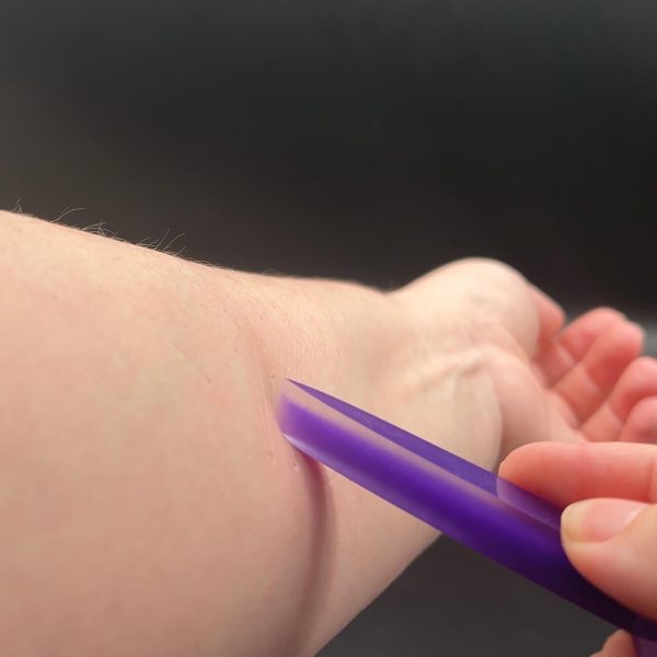 Another angle of the tip of the longsword pressed into Kayla's arm, creating an indent in the skin