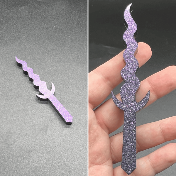 This Kris style dagger is made with black resin and a purple glittery mica. The glitter sank during the curing process leaving the front of the dagger a purple sparkle and the rest black.