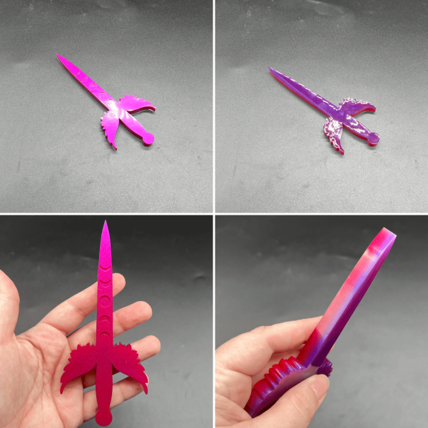 A small Poignard resin dagger made with red and purple resin. The purple is visible on the back and the red and purple mixed creates a hot pink appearance on the front side.