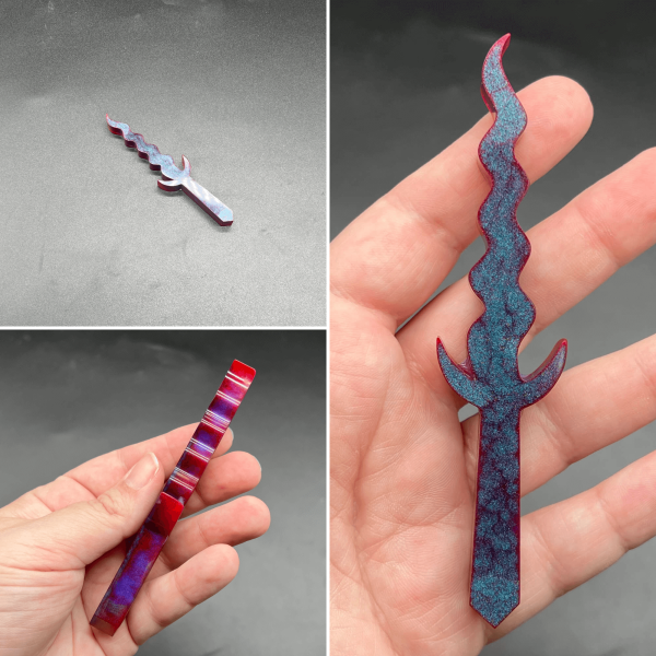 A Kris style dagger made with turquoise resin and red resin. The turquoise is visible on the front side and the red is visible throughout the dagger.