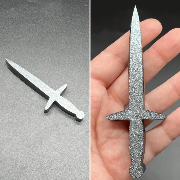 This longsword style dagger is made with black resin and white glitter. The glitter sunk to one side creating a silvery sparkle.