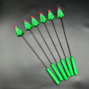 Green Christmas tree diabolical sticks with red ornaments and bows and a green handle