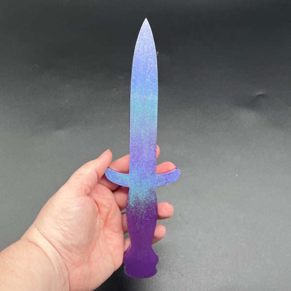 Resin dagger made with purple resin and a purple/blue holographic glitter on the blade