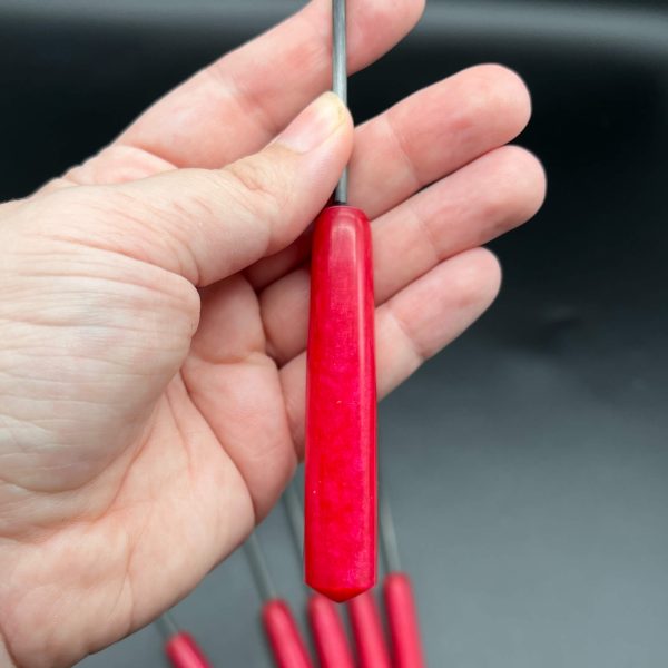 Close up of red resin handle - it's approximately 4 inches long and half an inch in diameter