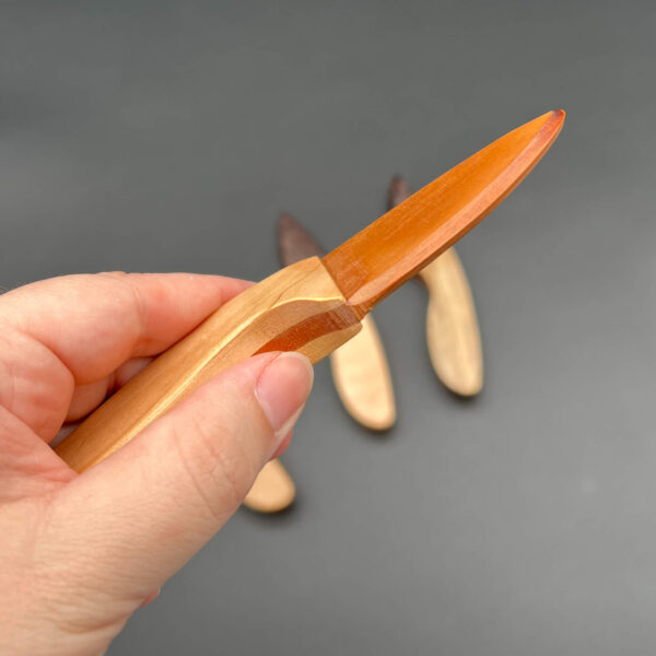 Close up of the cherry skinner wooden knife blade to show the clean, straight edge of the blade