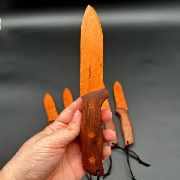 Full vertical view of the spearpoint wooden knife while being held
